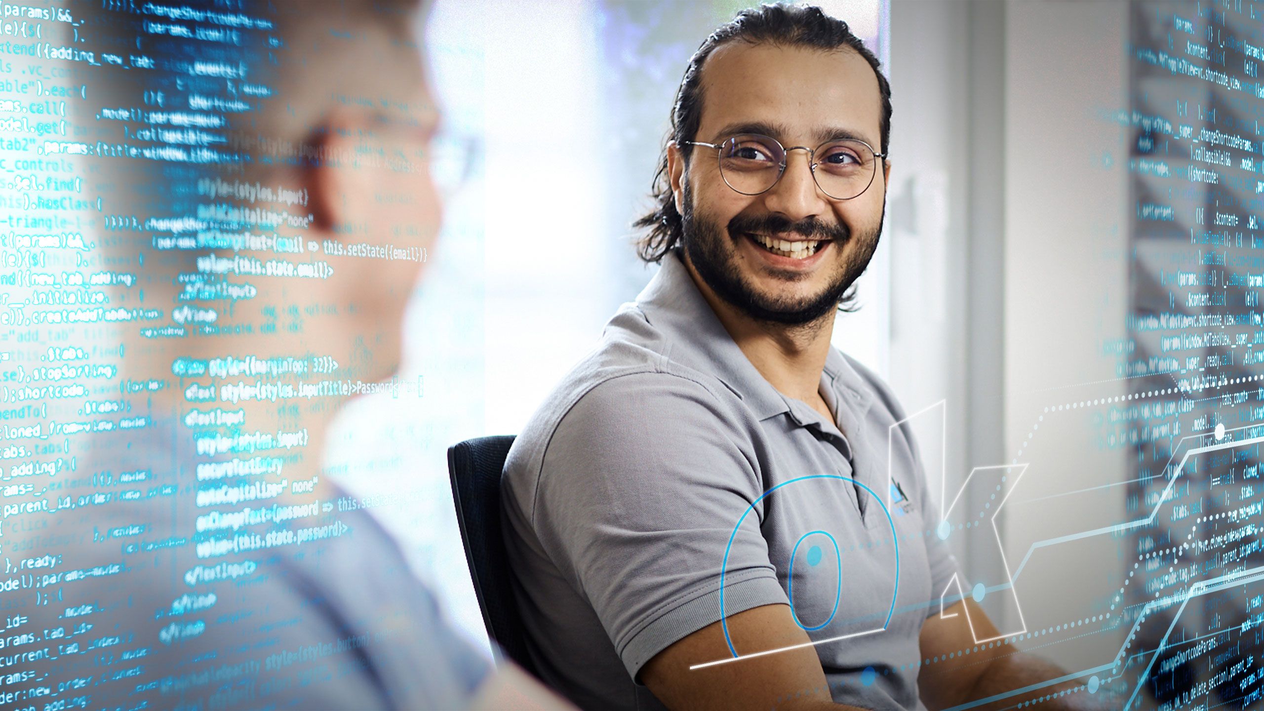 Zwei Mitarbeiter vor Programmiercode